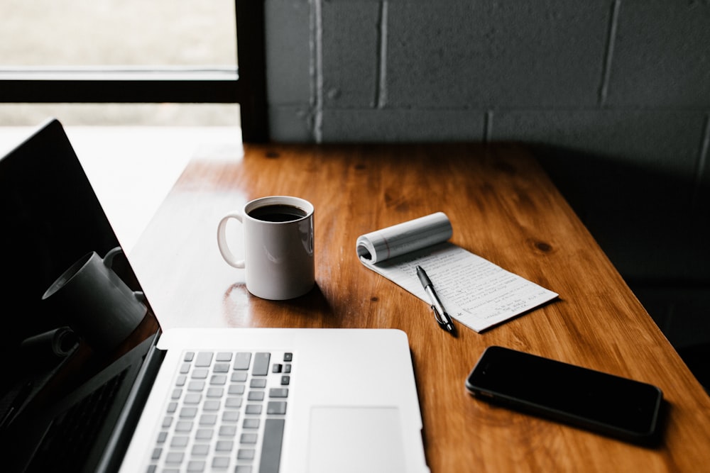 Person writing blog content at a desk with coffee