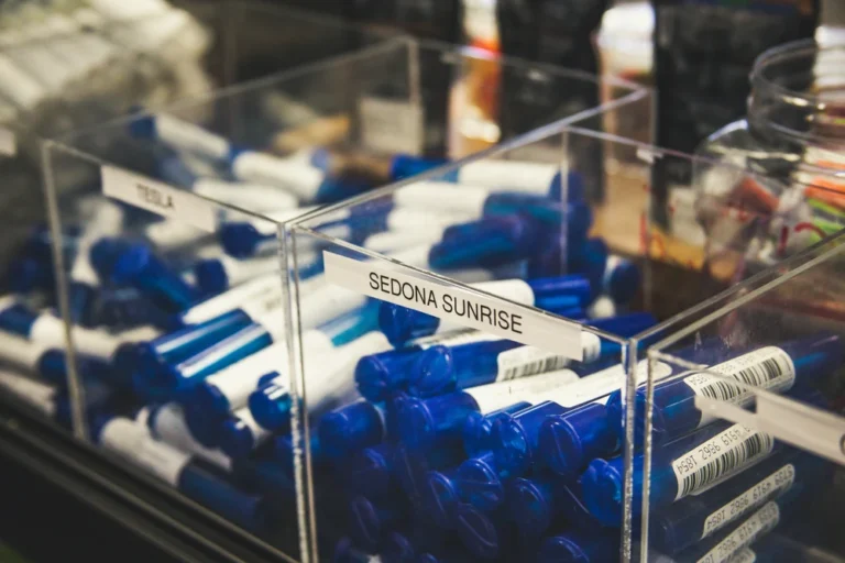 Cannabis dispensary display case showing labeled pre-roll products including Sedona Sunrise strain, representing organized product inventory at a local dispensary.