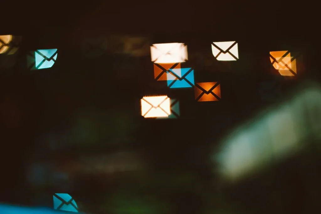 blurred, glowing email envelope icons scattered across a dark background
