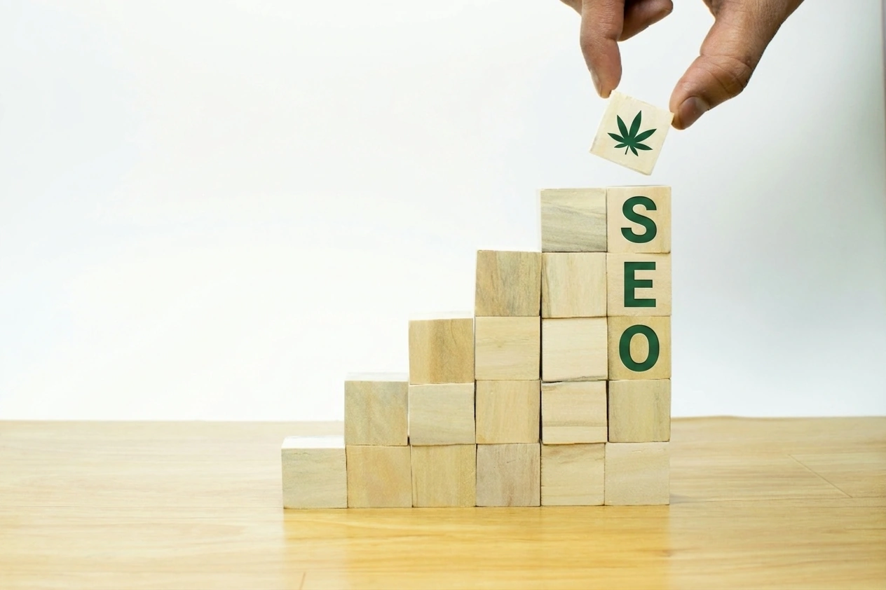 Wooden blocks spelling SEO with a cannabis leaf block being added, symbolizing compounding growth in cannabis marketing SEO