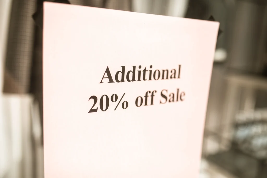 Store sign advertising an additional 20% off sale, representing the discount habit that trains dispensary customers to wait for deals